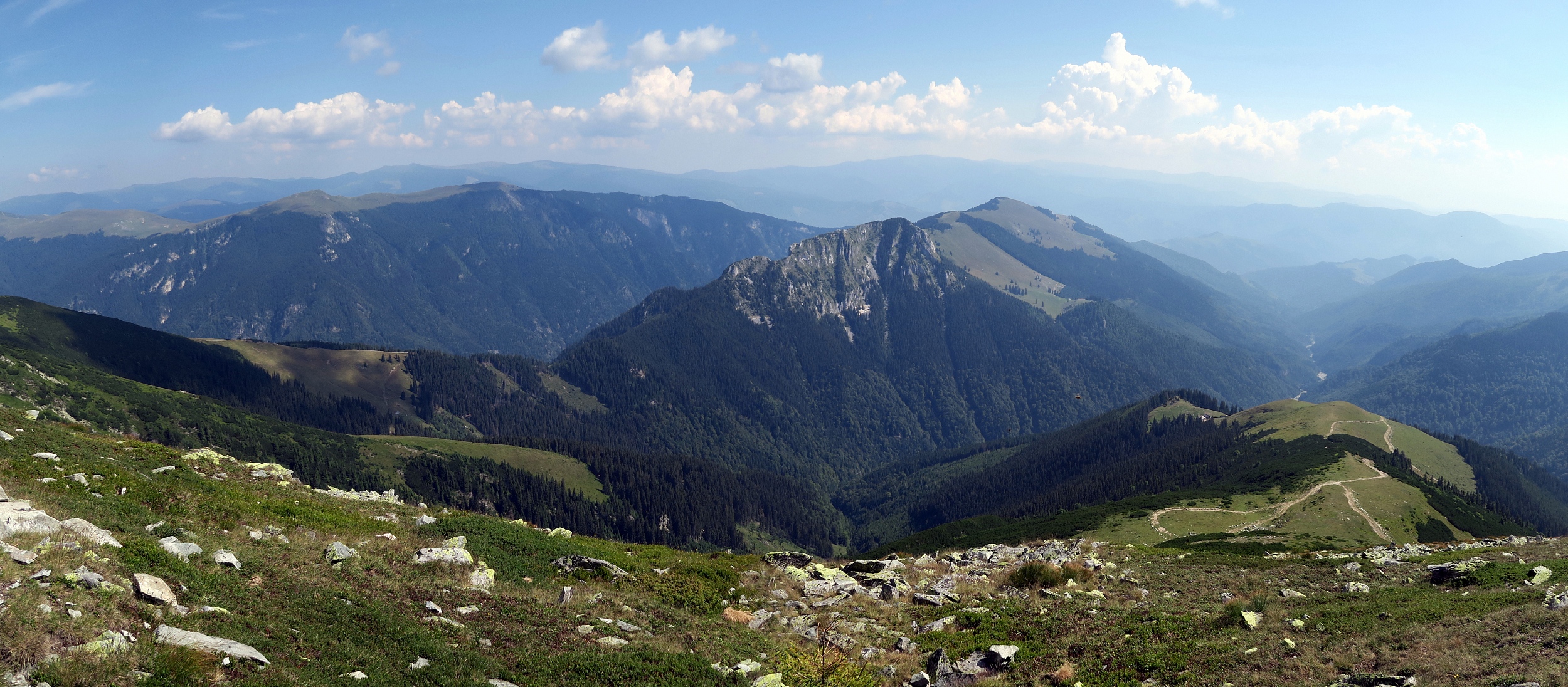 Munții Capatini / Panorama focené z nejvyššího vrcholu Nedeia. Vlevo od středu konec hřebene Latorita. Vpravo od středu vápencový hřeben Tirnovul (1847 m).